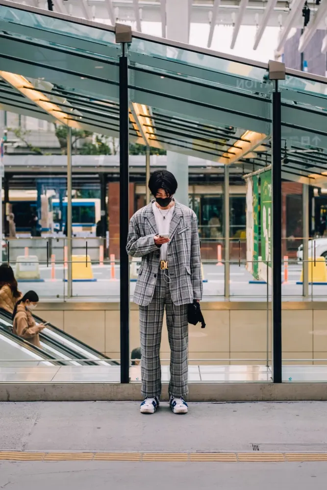 A man looking at his phone outside a train station